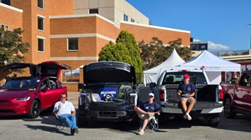 Catawba representatives at a tailgate event at Winston-Salem posing with electric vehicles