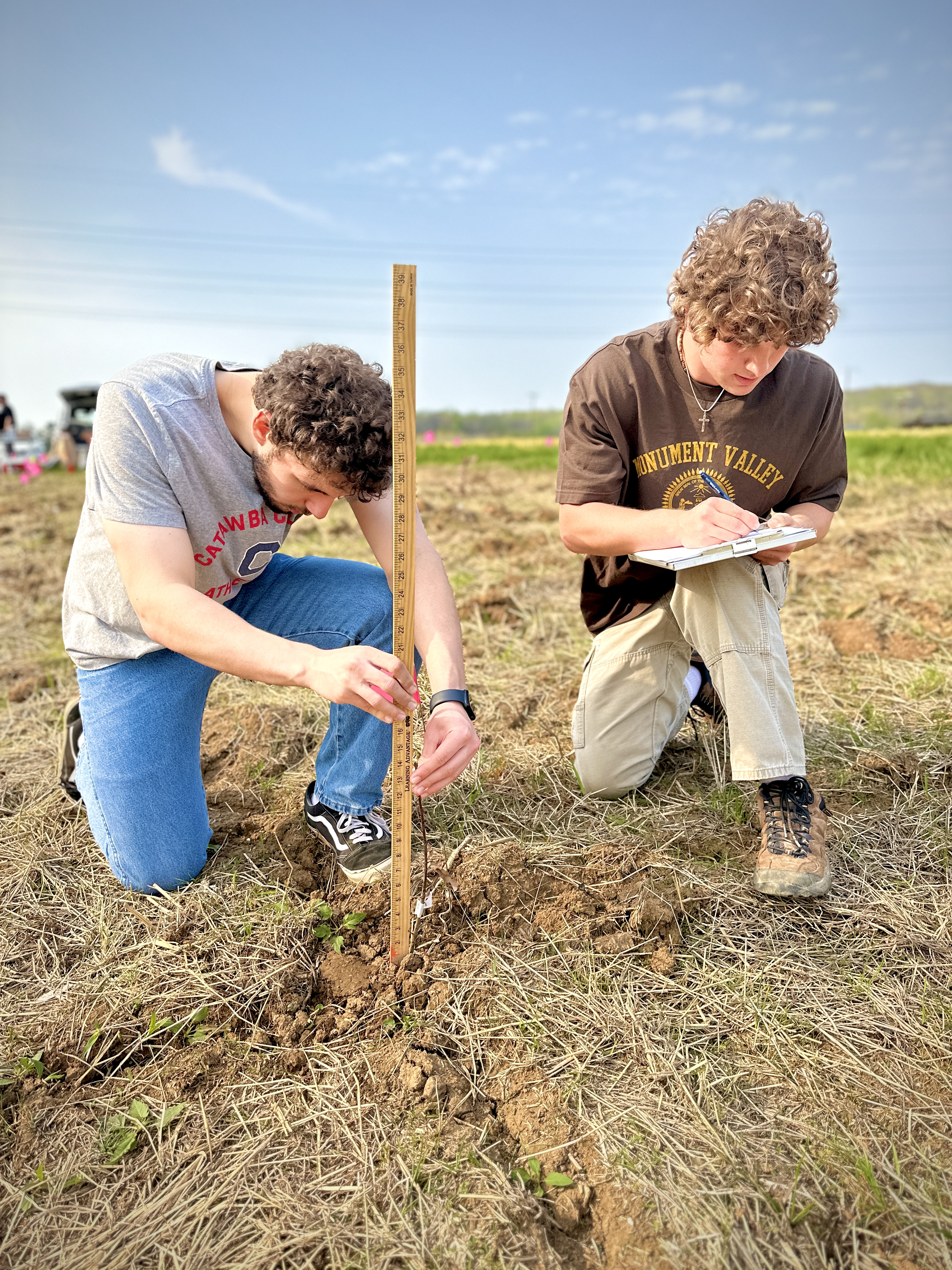 Two students planting white oak seedlings