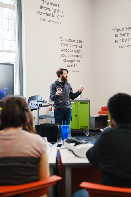 The library DLL staff member, Zach, teaching students how to use the VR headsets