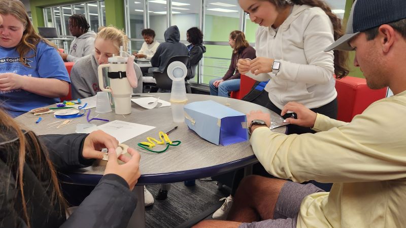 Students working with prototyping materials solving a problem